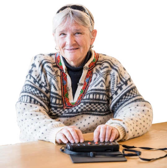 A blind woman smiles while using her Braille device.
